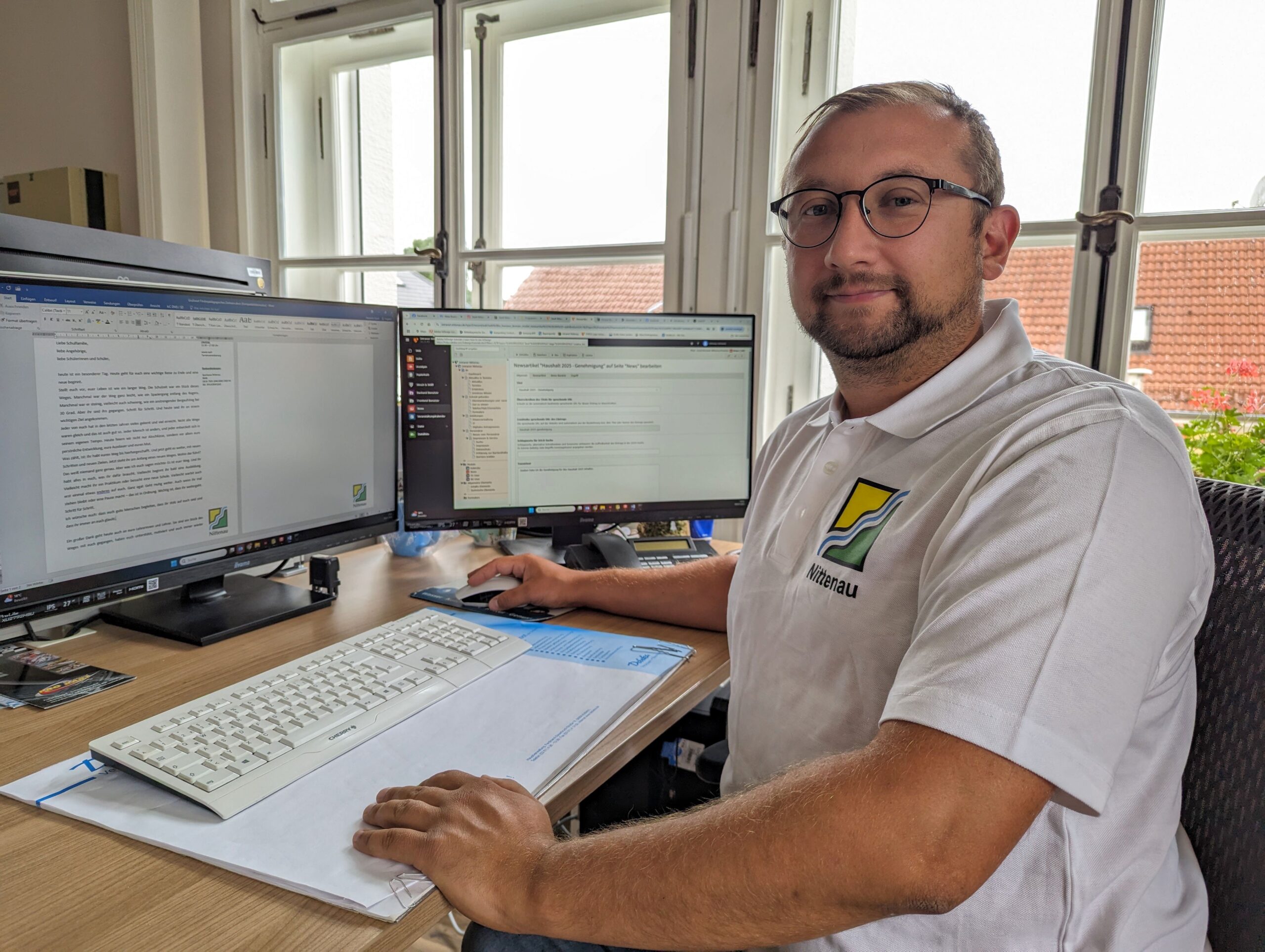 nittenau-town-damian-goj-it Employee of the city of Nittenau sits at a desk and looks into the camera