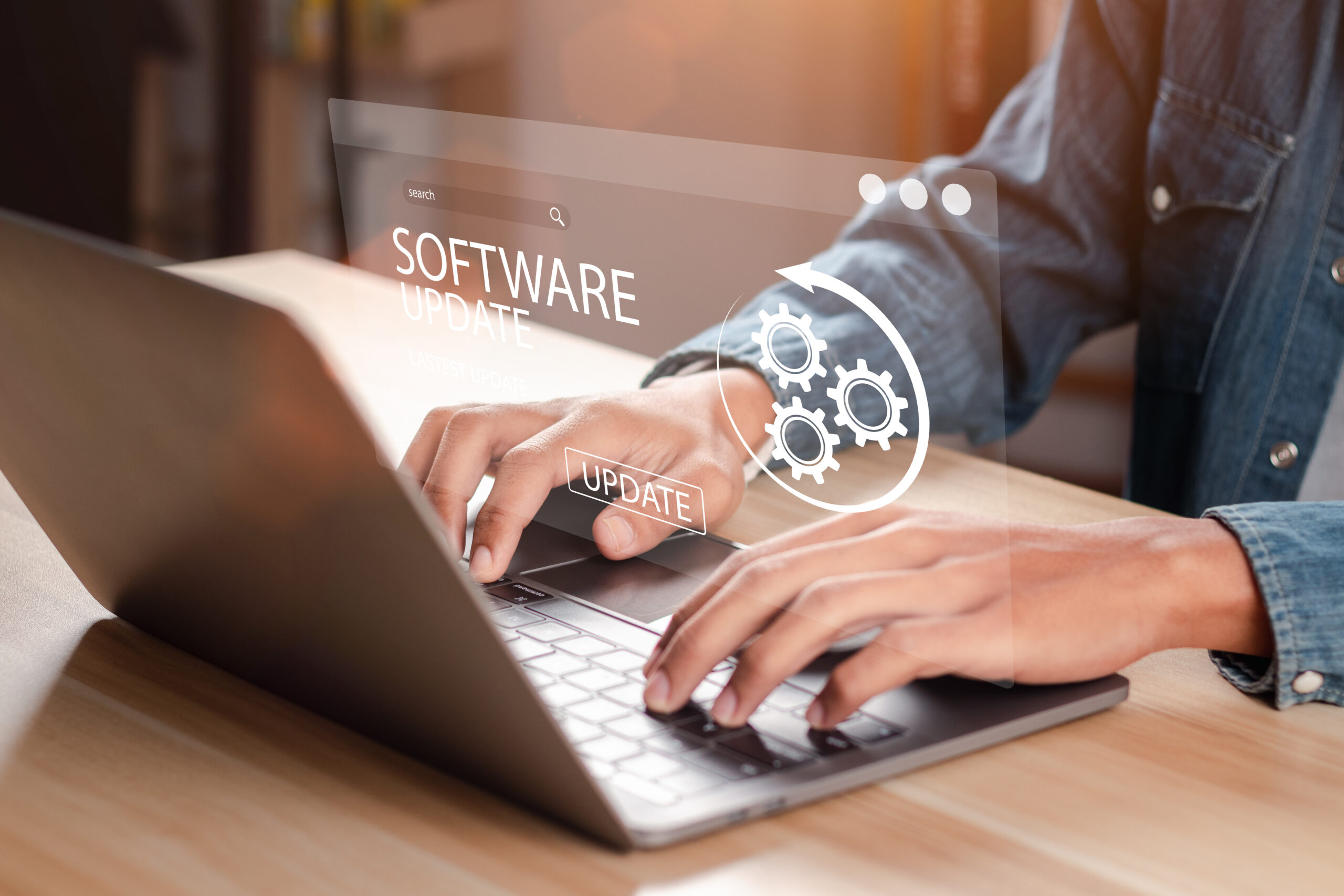 Eine Person tippt auf einem Laptop über dem das Wort Software zu sehen ist