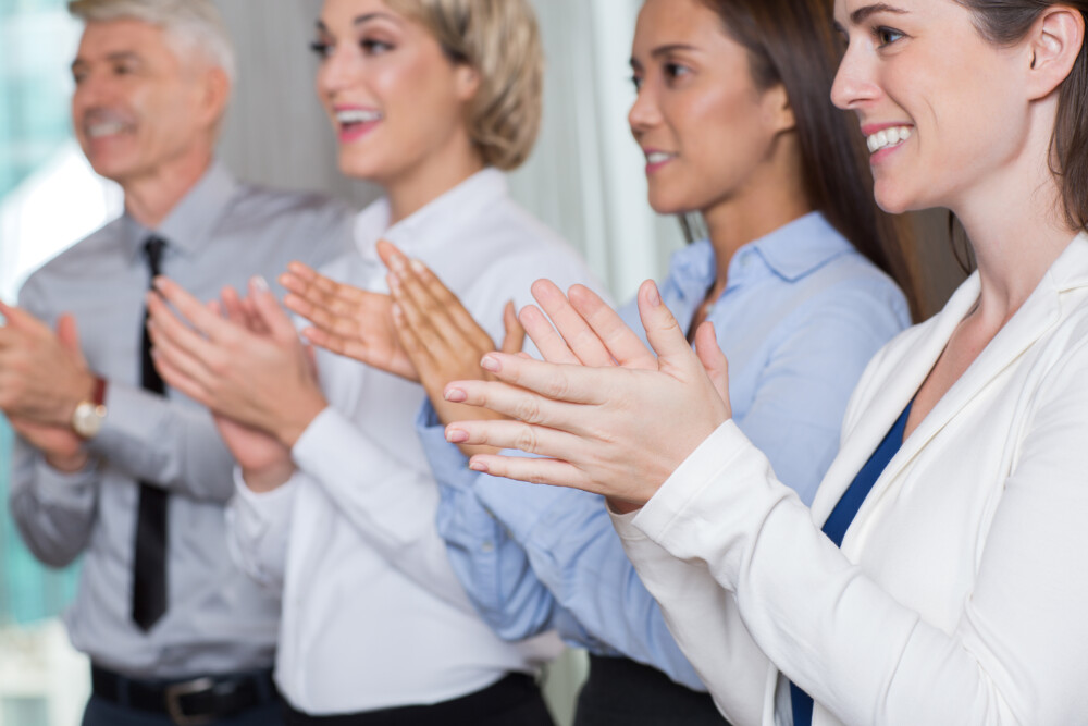 Close-up of Four Smiling Business People Applauding